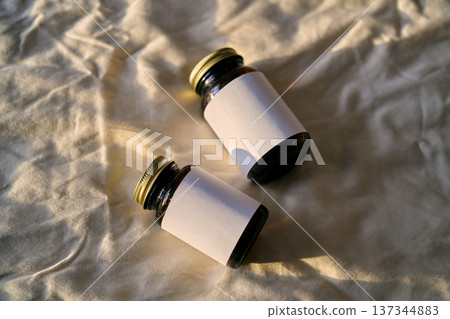 Two amber medical bottles with blank white labels 137344883