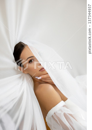 Bride holding veil looking away in wedding dress Bride holding veil looking away in wedding dress 137344937