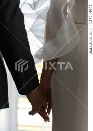 Groom and bride holding hands during wedding ceremony Groom and bride holding hands during wedding ceremony 137344941