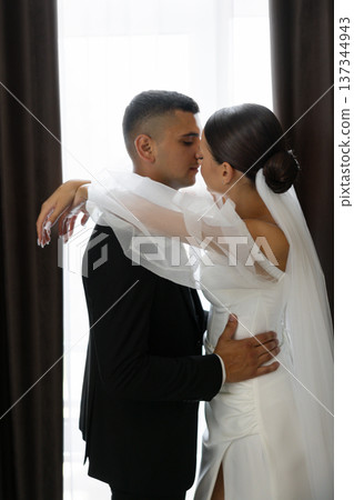 Groom kissing bride on forehead while embracing Groom kissing bride on forehead while embracing 137344943