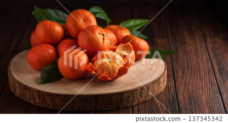 Fresh Tangerines with Leaves on Rustic Wooden Slab Fresh Tangerines with Leaves on Rustic Wooden Slab 137345342
