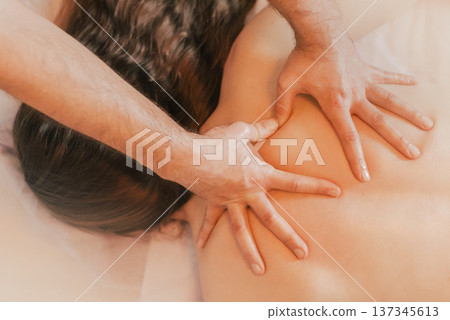 Massage Therapist Hands Applying Pressure to Clients Back 137345613