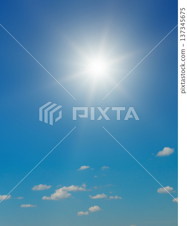 Bright Sun Shining in a Clear Blue Sky with Fluffy White Clouds 137345675