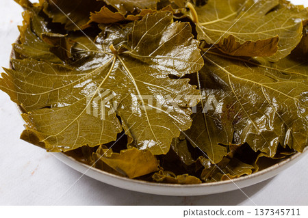 canned grape leaves, for cooking dolma, on a plate, 137345711
