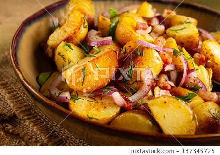 German potato salad with bacon, onions and herbs, plate on a wooden table, rustic style, no people, 137345725