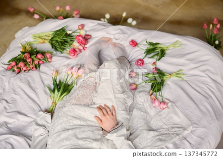 Tranquil aerial snapshot capturing woman in lace attire surrounded by colorful tulip displays 137345772