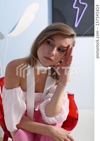 Lady showcasing delicate skincare steps against vibrant neon background Lady showcasing delicate skincare steps against vibrant neon background 137345814