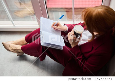 Freckled writer carefully composes with hot beverage at sunrise Freckled writer carefully composes with hot beverage at sunrise 137345865