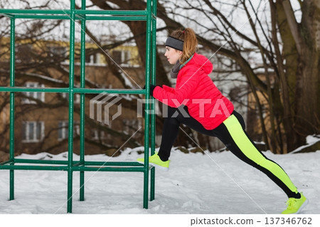 Woman urban exercising outside during winter Woman urban exercising outside during winter 137346762