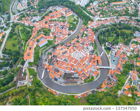 The charming town of Cesky Krumlov, Czech Republic, showcasing its UNESCO-listed castle, winding Vltava River, and beautiful orange-roofed buildings on a serene morning. 137347050