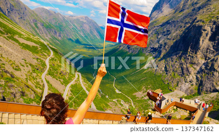Tourist with norwegian flag on Trollstigen viewpoint Tourist with norwegian flag on Trollstigen viewpoint 137347162