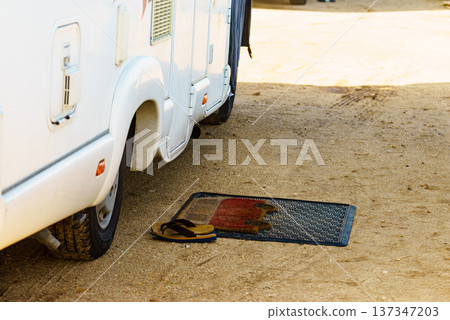 Flip flops on wiper in front of camper car 137347203