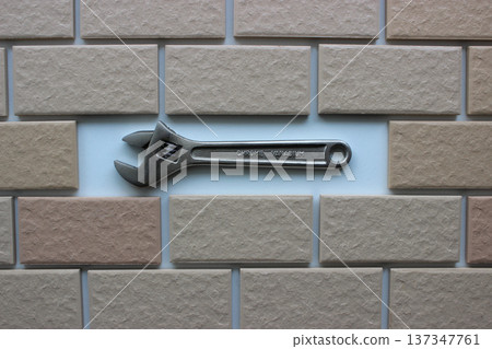 Adjustable Wrench In Compartment Inside Tiles Brickwork Top View. Stock Photo For DIY Repair Illustration Adjustable Wrench In Compartment Inside Tiles Brickwork Top View. Stock Photo For DIY Repair Illustration 137347761