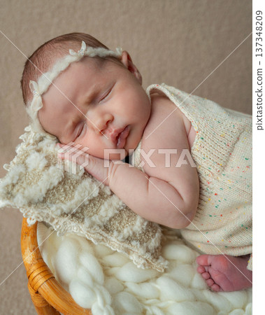 Close-up portrait of a sleeping newborn baby girl resting peacefully on soft knitted fabric. Warm neutral tones and delicate details highlight tenderness, innocence and the beauty of early motherhood. Close-up portrait of a sleeping newborn baby girl resting peacefully on soft knitted fabric. Warm neutral tones and delicate details highlight tenderness, innocence and the beauty of early motherhood. 137348209