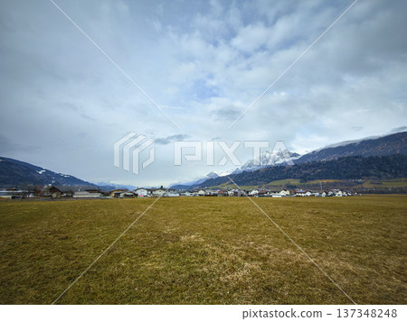 Serene Mountain Hamlet Surrounded By Snowy Summits And Lush Trees Serene Mountain Hamlet Surrounded By Snowy Summits And Lush Trees 137348248