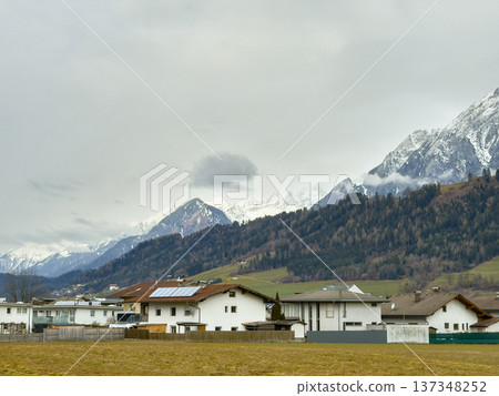 Serene Mountain Hamlet Surrounded By Snowy Summits And Lush Trees Serene Mountain Hamlet Surrounded By Snowy Summits And Lush Trees 137348252