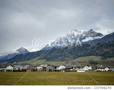 Serene Mountain Hamlet Surrounded By Snowy Summits And Lush Trees 137348270