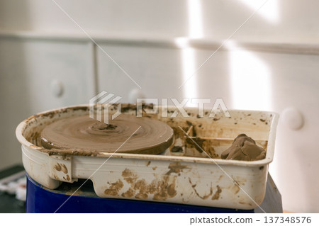 Young woman shaping clay on pottery wheel in ceramic workshop, handmade pottery process and creative craft activity in studio Young woman shaping clay on pottery wheel in ceramic workshop, handmade pottery process and creative craft activity in studio 137348576