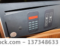 Open electronic hotel safe with keypad inside wooden cabinet 137348633