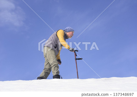 An elderly man living in a snowy rural area is using a walking stick for rehabilitation An elderly man living in a snowy rural area is using a walking stick for rehabilitation 137348697