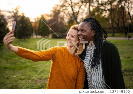Diverse women friends taking selfie in park, sharing joy 137349100
