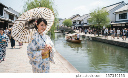 A young woman strolling around Kurashiki's scenic area in a yukata 137350133