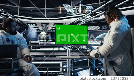 Astronaut reviewing onboard analytics on green screen monitor before stepping outside space station. Cosmonaut verifying parameters on mockup display after landing on planet Astronaut reviewing onboard analytics on green screen monitor before stepping outside space station. Cosmonaut verifying parameters on mockup display after landing on planet 137350524