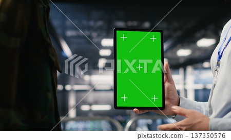 Military technicians in data center use green screen mockup tablet to monitor systems. Army operators in server room ensuring stable infrastructure using chroma key device Military technicians in data center use green screen mockup tablet to monitor systems. Army operators in server room ensuring stable infrastructure using chroma key device 137350576