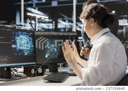 Data center team of admins doing brainstorming, using artificial intelligence neural networks tech. Server farm teamworking colleagues using AI programming language on computer to update equipment 137350640