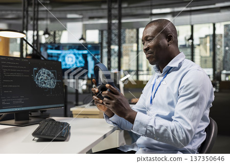 Smiling technician in office automating repetitive tasks using AI, listening music. Startup IT employee putting on audio headphones, using neural network on PC to speed up feature implementation 137350646