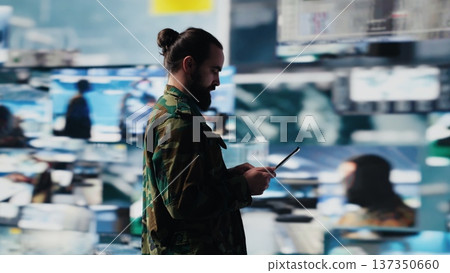 Army officer working in a virtual war zone with digital tech and satellite data, using threat detection tools for national safety. Modern military strategy to ensure control in a mission. Camera A. 137350660