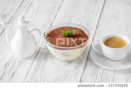 Classic Italian tiramisu dessert in glass bowl with espresso and milk jug Classic Italian tiramisu dessert in glass bowl with espresso and milk jug 137350876