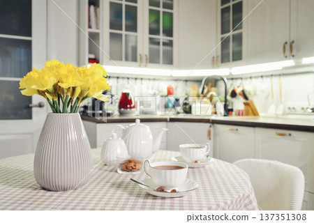 A table set for breakfast with tea and a bouquet of daffodils 137351308