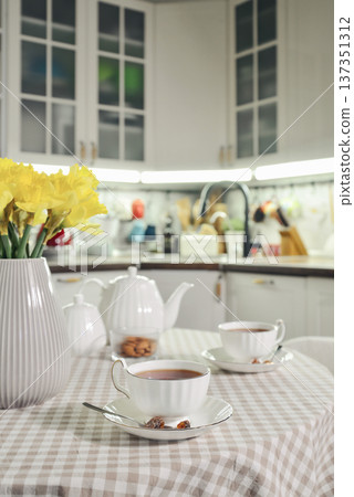 A table set for breakfast with tea and a bouquet of daffodils A table set for breakfast with tea and a bouquet of daffodils 137351312