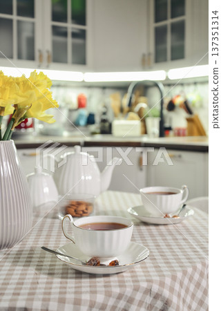 A table set for breakfast with tea and a bouquet of daffodils A table set for breakfast with tea and a bouquet of daffodils 137351314