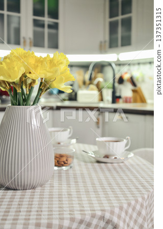 A table set for breakfast with tea and a bouquet of daffodils A table set for breakfast with tea and a bouquet of daffodils 137351315