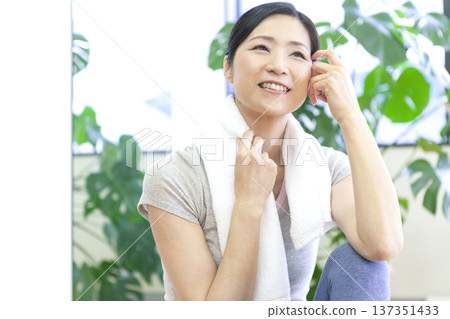 一名女子坐在健身房的地板上。 137351433