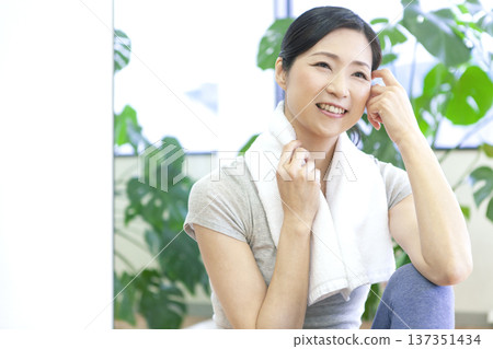 一名女子坐在健身房的地板上。 137351434