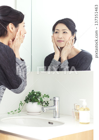 Middle-aged woman looking in the mirror 137351463