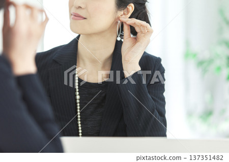 女人在鏡子前戴耳環 137351482