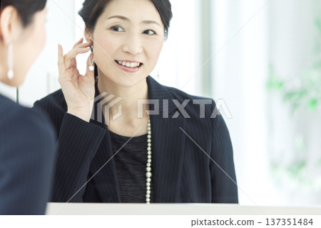 女人在鏡子前戴耳環 137351484
