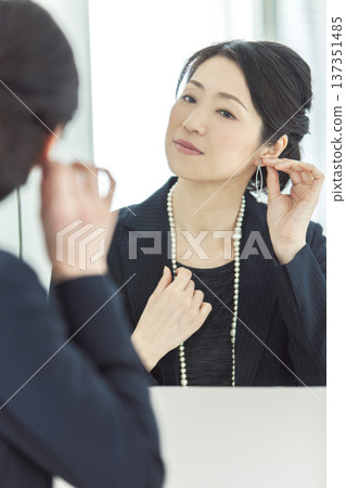 女人在鏡子前戴耳環 137351485