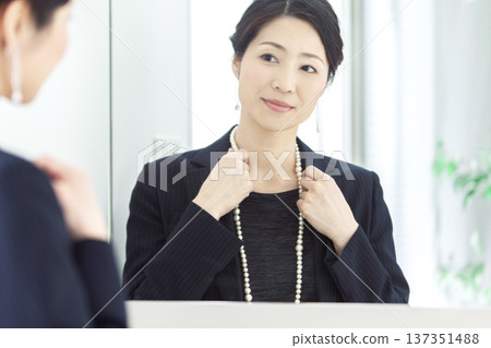 Middle-aged woman looking in the mirror Middle-aged woman looking in the mirror 137351488