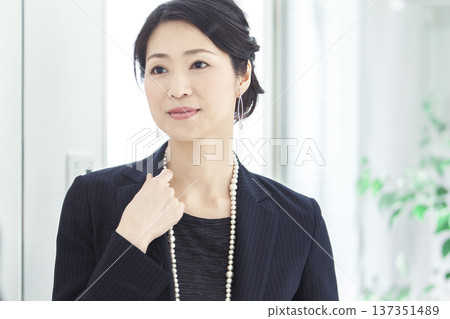 Middle-aged woman looking in the mirror Middle-aged woman looking in the mirror 137351489
