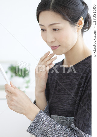 A woman watching a hand mirror 137351500