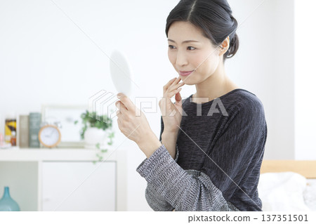 A woman watching a hand mirror A woman watching a hand mirror 137351501