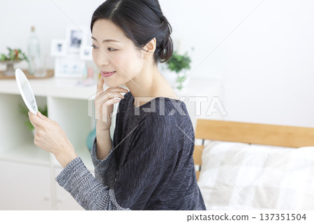 A woman watching a hand mirror 137351504