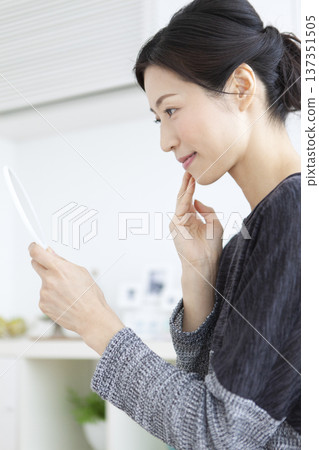 A woman watching a hand mirror 137351505