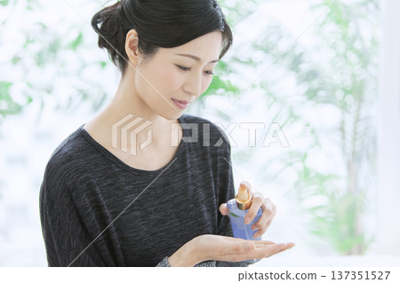 Middle-aged woman holding cosmetics Middle-aged woman holding cosmetics 137351527