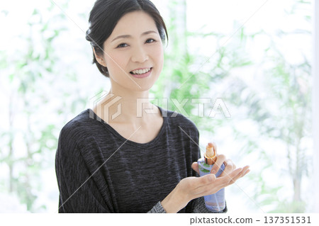 Middle-aged woman holding cosmetics Middle-aged woman holding cosmetics 137351531